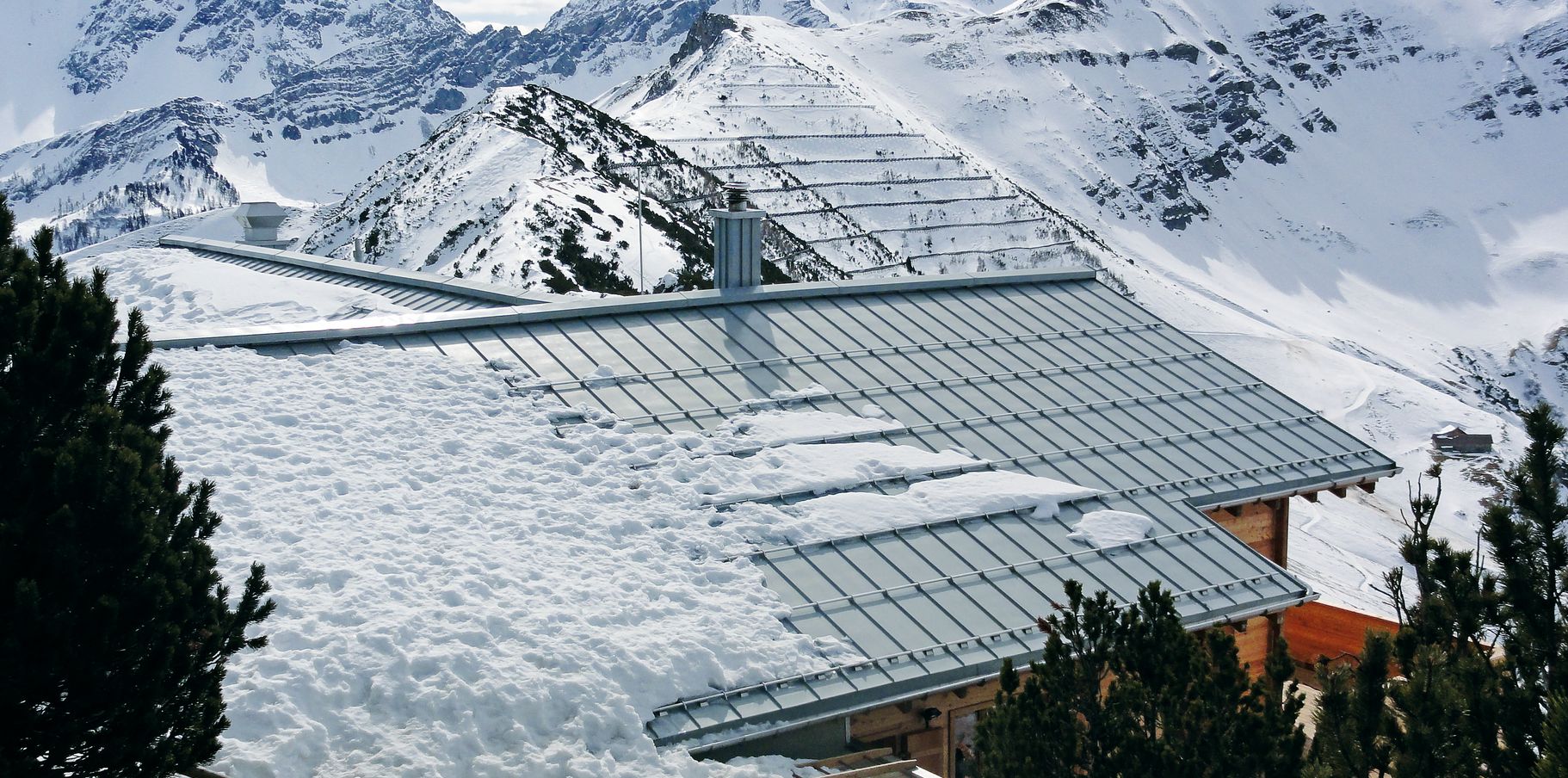 Dachfläche aus Zink in Schneelandschaft mit Schneestopp